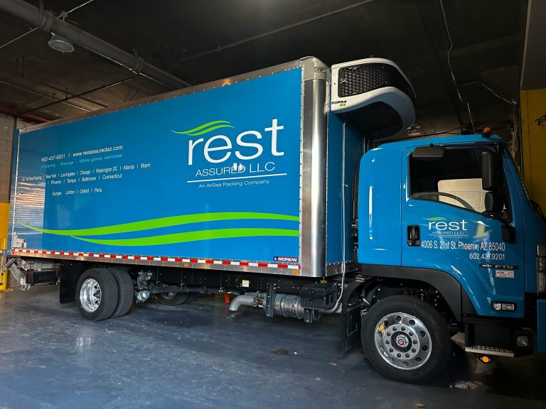 Rest Assured box truck with blue and green vinyl side graphics by Vinyl Images NY